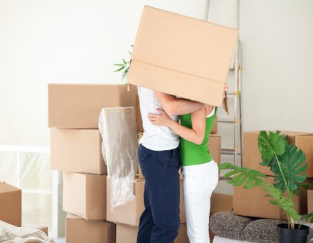 Professional movers carrying furniture during a local house move
