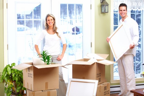 Professional movers carrying furniture through a local property entrance